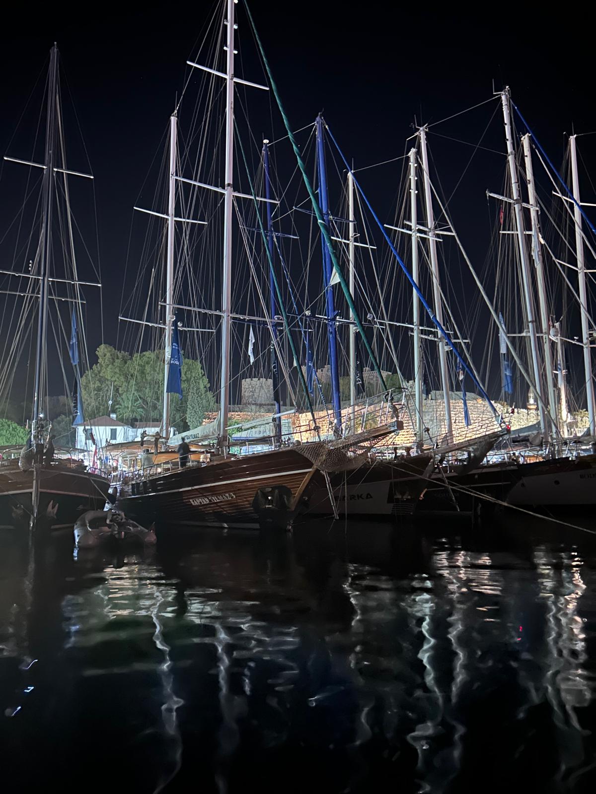 Gece Bodrum Limanı’nda gulet direkleri ve arkada aydınlatılmış Bodrum Kalesi